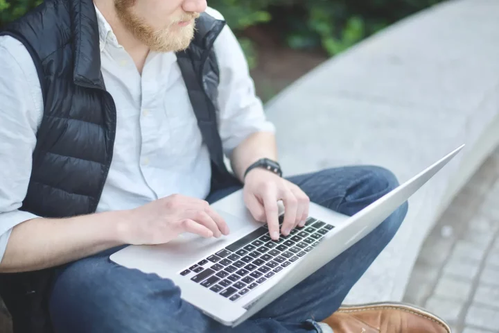 Ciudadania italiana: multa - Hombre sentado frente a la computadora actualizando el registro AIRE