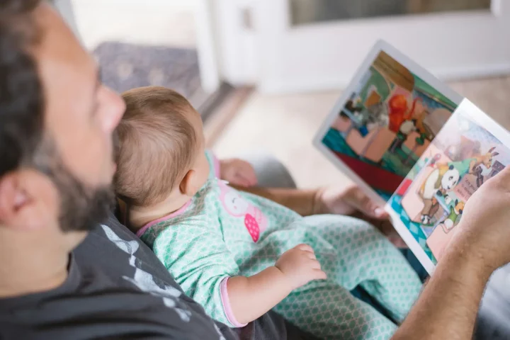 Ciudadania italiana por padre: Padre leyendo un libro a su hijo.