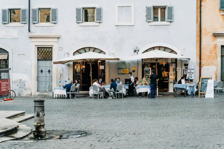 Cómo evitar fraudes en asesorías de ciudadanía italiana: Foto de personas en un restaurante en Roma almorzando