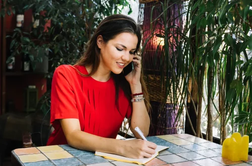 Mujer utilizando las guías telefónicas de Italia para rastrear sus raíces familiares.