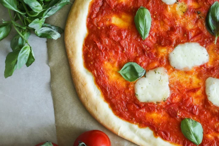Descubre el origen de la pizza margarita: la historia oficial, las teorías que la cuestionan y el misterio detrás del mito napolitano más famoso.