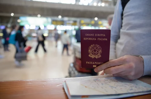 Renovación del pasaporte italiano: Foto de una persona presentando su pasaporte italiano en un mostrador.