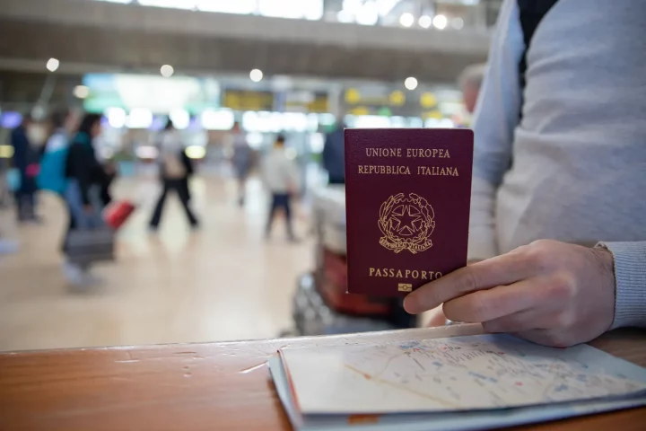 Renovación del pasaporte italiano: Foto de una persona presentando su pasaporte italiano en un mostrador.