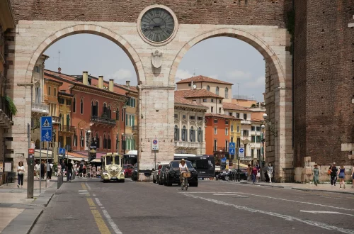 Vivir en italia siendo español: Foto de personas y coches en la ciudad de Verona.